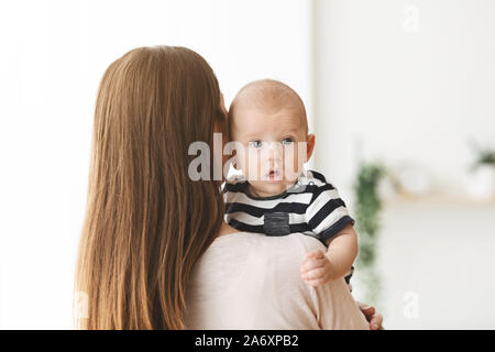 Süße kleine Baby liegend auf Mutters Schulter Stockfoto