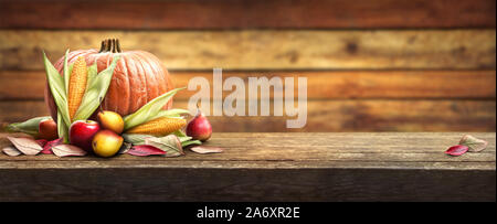 Einen weiten Panoramablick Thanksgiving Feier Tabelle der Kürbisse, Äpfel, Birnen und Maiskolben mit einem hölzernen Hintergrund. Stockfoto