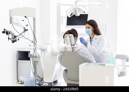 Ziemlich Zahnarzt Arzt die Behandlung von Patienten in der Zahnarztpraxis Stockfoto