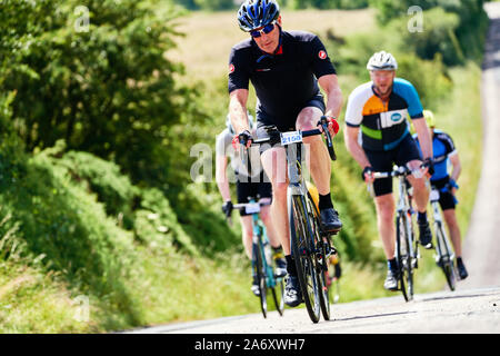 ROTHBURY, NEWCASTLE UPON TYNE, England, UK - Juli 06, 2019: eine kleine Gruppe von Radfahrern schwer arbeiten, einem Hügel an der Zyklon Rennen von Newcastle Stockfoto