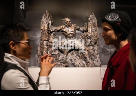 (191029) - NEW YORK, Oktober 29, 2019 (Xinhua) - Hong Mei (L), geschäftsführender Kurator von Liu Shiming Skulptur Museum an der Zentralen Akademie der Bildenden Künste, stellt ein Kunstwerk auf 'Departure und Zurück", eine Ausstellung von verstorbenen chinesischen Bildhauer Lius Shiming arbeitet, in New York, in den Vereinigten Staaten, Okt. 28, 2019. Die Ausstellung 'Departure und Zurück", "Die von Okt. 28 bis Nov. 8 an den asiatischen Kulturzentrum läuft, verfügt über Dutzende von Skulpturen aus Bronze von Liu, der sich im Jahr 2010 im Alter von 84 Jahren bestanden. Die Ausstellung ist die erste Etappe einer World Tour von Lius Werke, die von der zentralen Acade organisiert ist Stockfoto