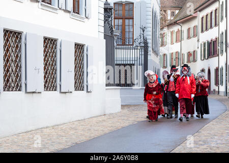 Martinsgasse, Basel, Schweiz - März 13., 2019. Kleine Gruppe von Teilnehmern in rot Karneval Kostüme Stockfoto