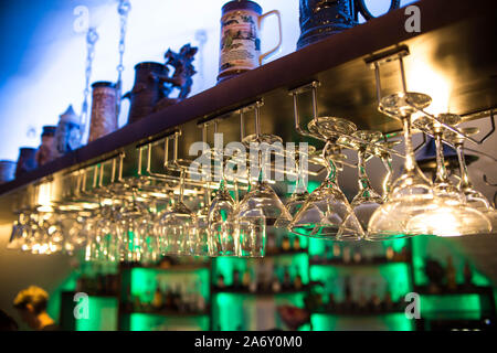 Schönen cocktail Gläser in der Bar hängen über der Tabelle. Nachtclub. Alkoholische Getränke, viele Weingläser haben unterschiedliche Formen. Counter Bar Stockfoto