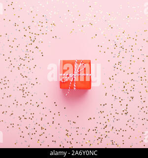 Kreatives Weihnachtsgeschenk in kleinen roten Kästchen auf Rosa Stockfoto