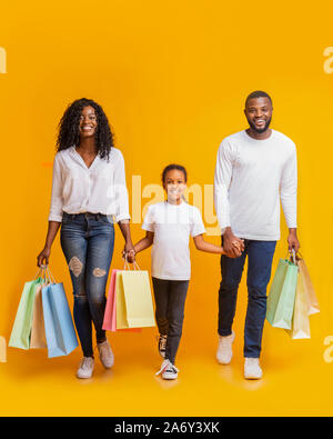 Afrikanische amerikanische Familie von drei gehen mit Einkaufstaschen im Studio Stockfoto