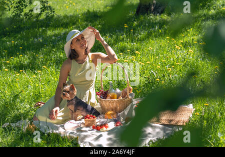 Frau in einem weißen Hut auf ein Picknick im Wald Stockfoto