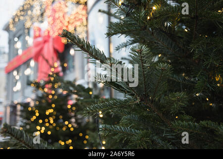 Weihnachtsbaum mit Girlanden und verschwommenes Luxus Shopping Mall im Hintergrund. Outdoor. Weihnachten Urlaub. Winter. Give-away. Stockfoto