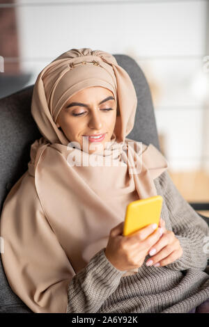 Schönen muslimischen Mädchen felling glücklich, während Sie das Telefon Stockfoto