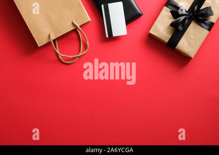 Schwarzer Freitag verkauf Konzept. Rahmen aus Geschenkbox, EC-Karte und Shopping Bag über den roten Hintergrund Stockfoto