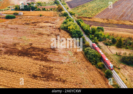 Red Personenzug über Land reisen, Luftaufnahme von Drone pov im Herbst am Nachmittag Stockfoto