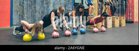 Training mit kettlebells Sportlerinnen und Sportler tun Box springt Stockfoto