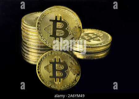 Ein Spiegelbild eines goldenen BTC Münzen auf schwarzem Hintergrund-Bild Stockfoto
