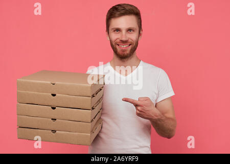 Kurier hält viele Pizzakartons auf Wand isoliert Stockfoto