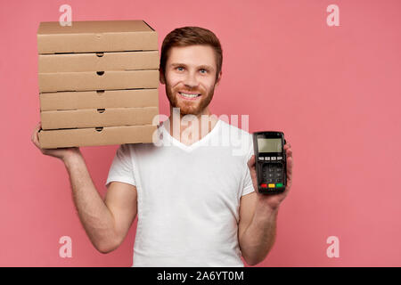 Kurier hält viele Pizzakartons auf Wand isoliert Stockfoto