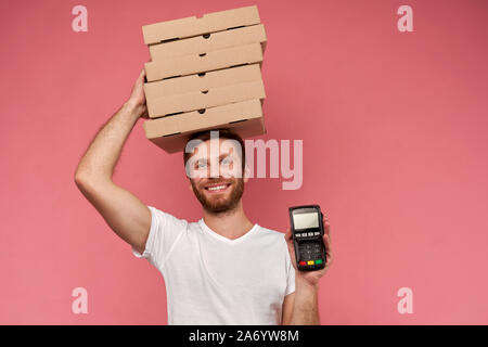 Kurier hält viele Pizzakartons auf Wand isoliert Stockfoto