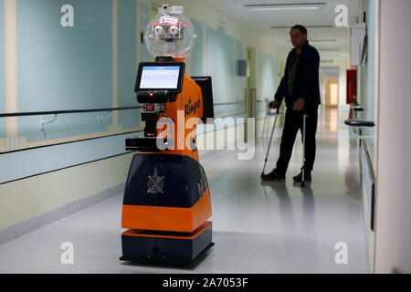 29. Oktober 2019, Thüringen Eisenberg: ein Patient Züge mit Hilfe von Ringo, ein Roboter, Wandern in einem Flur im Krankenhaus Waldkliniken Eisenberg. In einem dreijährigen Forschungsprojekt, der Einsatz von Robotern für Gang Übungen mit Patienten nach Hüftoperationen wurde entwickelt und getestet. Der Roboter arbeitet autonom und erkennt falsche Körperhaltungen, wie der Patient geht, korrigiert sie und lobt die Fortschritte. Die Studie zeigte, dass Patienten, die zusammen mit dem Roboter Zug schneller als diejenigen, die allein Zug gehen können. Nach Einschaetzung der Teilnehmer ist das Projekt ist einzigartig in Deutschland und international in der Medica Stockfoto