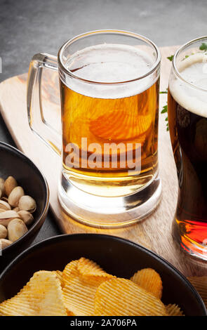 Bier vom Fass und Snacks auf Stein. Nüsse und Chips Stockfoto