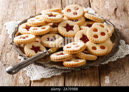 Weihnachten shortbread Linzer Kekse mit Marmelade in der Nähe der Befüllung bis auf einen Teller auf den Tisch. Horizontale Stockfoto
