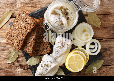 Für marinierte Heringe mit Zwiebeln, Essig, Rezept, Gewürze in Öl in einer Bank in der Nähe - Auf den Tisch. Horizontal oben Ansicht von oben Stockfoto