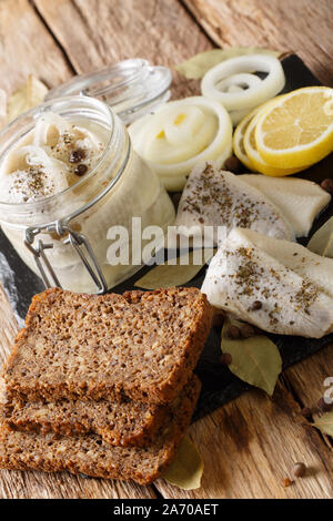 Traditionelle Rollmops in ein Glas mit Zutaten close-up auf dem Tisch. Vertikale Stockfoto