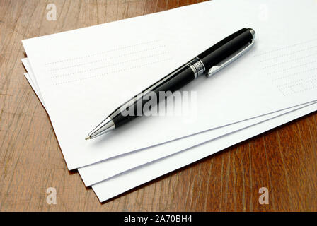 Stapel von Briefumschlägen auf einem braunen Tisch Stockfoto