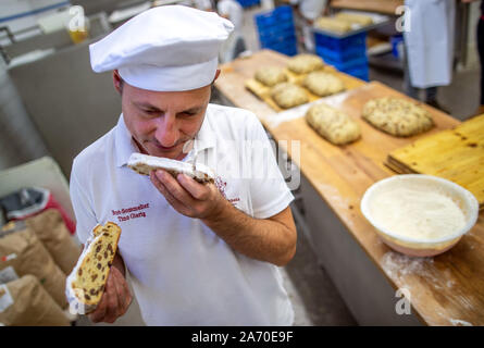 18. Oktober 2019, Sachsen, Dresden: Bäckermeister und Geschäftsführer Tino gierig versucht, eine frisch gebackene Christstollen in der Dresdner Bäcker. Der Dresdner Christstollen ist um rund 130 Bäckereien und Konditoreien in und um Dresden nach traditionellen Rezepturen handgefertigt. Nur die Bolzen, die den Anforderungen der Stollen Protection Association erfüllen, kann der Bolzen Dichtung als ein Zeichen der Echtheit. Foto: Jens Büttner/dpa-Zentralbild/ZB Stockfoto