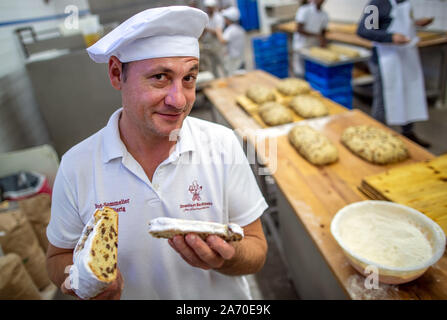 18. Oktober 2019, Sachsen, Dresden: Bäckermeister und Geschäftsführer Tino gierig versucht, eine frisch gebackene Christstollen in der Dresdner Bäcker. Der Dresdner Christstollen ist um rund 130 Bäckereien und Konditoreien in und um Dresden nach traditionellen Rezepturen handgefertigt. Nur die Bolzen, die den Anforderungen der Stollen Protection Association erfüllen, kann der Bolzen Dichtung als ein Zeichen der Echtheit. Foto: Jens Büttner/dpa-Zentralbild/ZB Stockfoto