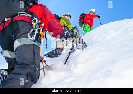 Alpinisten klettern in steilen und schneebedeckte Berge mit einer Axt Stockfoto