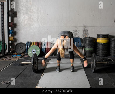 Vorderansicht des weiblichen Gewichtheber gebogen über Fertig, schwere Hantel zu heben. Stockfoto