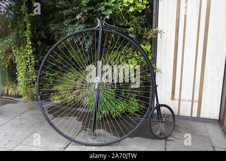 Ein Penny Farthing Fahrrad steht vor dem Athenaeum Hotel Mayfair, mit Garten an der Wand Stockfoto