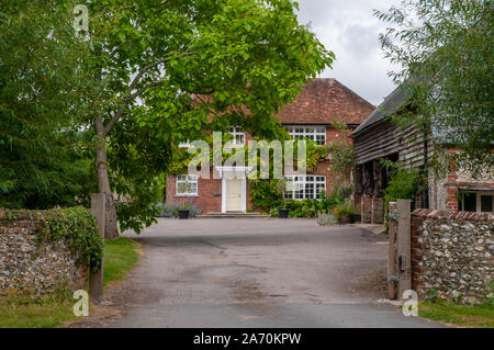 Auffahrt und vor einer großen privaten traditionellen roten Backsteinhaus in Exton Dorf, Hampshire, England. Stockfoto