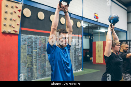 Sportler trainieren mit kettlebell mit seinen Partnern Stockfoto