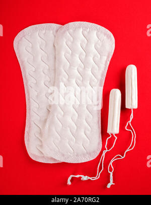 Die Menstruation. Damenbinden und Tampons auf rotem Hintergrund Stockfoto