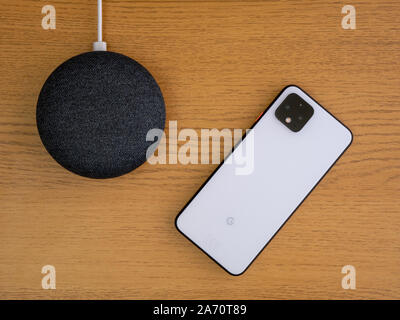 Großbritannien, Oktober 2019: Pixel 4 smart phone und Google nest Mini auf Holz Couchtisch Stockfoto