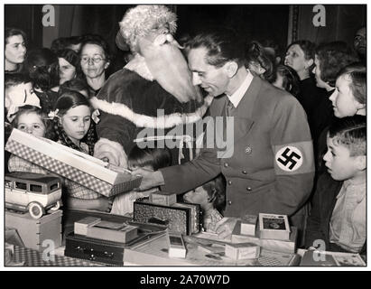 1930 von Dr. Goebbels Propaganda Minister Nazi Partei tragen ein Hakenkreuz Armbinde in einem Propaganda bild Christmas shopping Szene, Vater Weihnachten hinter, Goebbels mit seinen Kindern Hilde & Helga in Berlin Deutschland Stockfoto