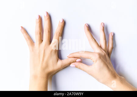 Schöne weibliche Hände. Mit sanft rosa Maniküre. Auf einem weißen Hintergrund isoliert Stockfoto