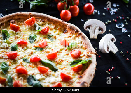 Leckere italienische Pizza mit Tomaten, frischem Basilikum & Gorgonzola Stockfoto