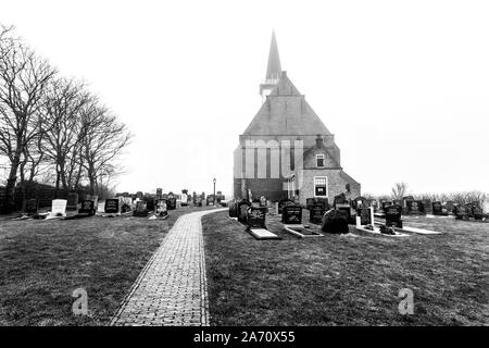 Den Hoorn, Niederlande - 25. Februar 2010: Herbst nebeliger Morgen, Friedhof vor der Kirche von Den Hoorn auf der Insel Texel in den Niederlanden. Stockfoto