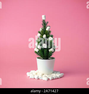 Weihnachtsbaum mit Marshmallows statt Spielzeug auf einem rosa Hintergrund eingerichtet. Minimalen Begriff. Stockfoto