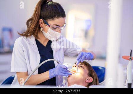 Frau erhält der zahnmedizinischen Behandlung in einer Zahnarztpraxis. Stockfoto