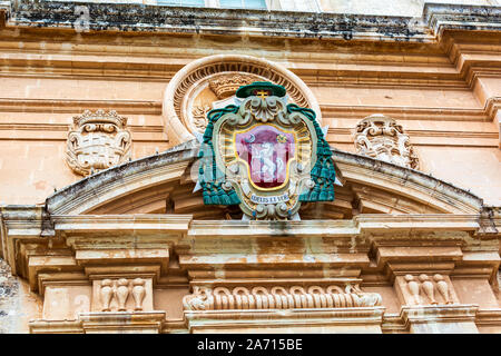 Farbige Wappen des Erzbischofs über dem Haupteingang der St. Paul Kathedrale in Mdina, Malta. Stockfoto