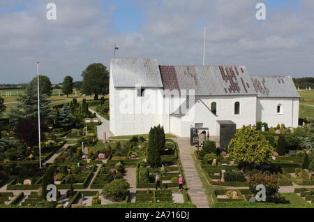 JELLING, Dänemark, 15. JULI 2019: Außenansicht der Kirche von Jelling und der umliegende Friedhof und Runensteine. Die Kirche ist auf der UNESCO-Liste Stockfoto