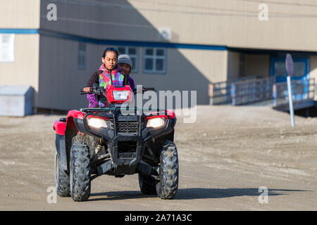 Einen lokalen Inuit Mädchen fahren eines Quadricycle in Clyde River, Kanada. Stockfoto