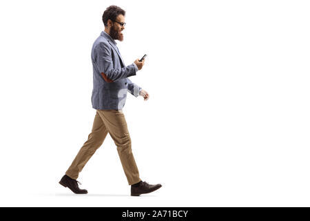 Volle Länge Profil Schuß eines bärtigen Mann zu Fuß und mit Blick auf sein Handy auf weißem Hintergrund Stockfoto