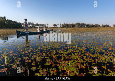 Safari Guide mit einem Touristen in einem makoro (Einbaum) auf dem Okavango Delta im Norden von Botswana, Afrika. Stockfoto