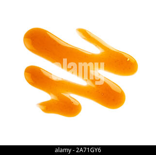 Caramel Sirup Nieselregen auf weißem Hintergrund. Spritzer von süßem Karamell Sauce. Ansicht von oben. Stockfoto