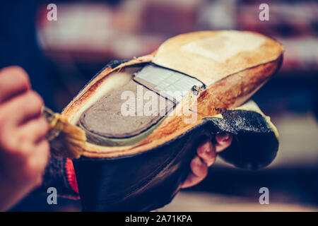 Die Hände eines erfahrenen Arbeiter in den handgefertigten Schuhindustrie, alleinige kleben Aufgaben, Leim auf die Teile der Schuh. Stockfoto