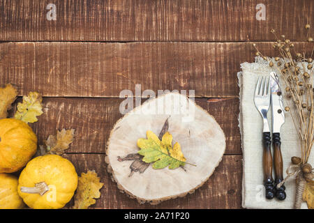 Rustikal gedeckten Tisch für Thanksgiving Dinner mit Herbst Blätter, Eicheln und Kürbisse für die Dekoration. Ansicht von oben mit der Kopie. Stockfoto