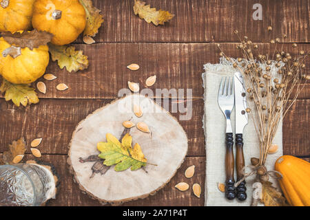 Rustikal gedeckten Tisch für Thanksgiving Dinner mit Herbst Blätter, Eicheln und Kürbisse für die Dekoration. Ansicht von oben mit der Kopie. Stockfoto