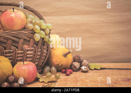 Herbst Stillleben mit Früchten, Kürbisse, Hagebutten und die Muttern an den hölzernen Tisch, kopieren. Vintage Farben Foto. Stockfoto